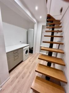 une chambre avec un escalier et une cuisine avec une cuisinière dans l'établissement Maison plein cœur de Rosendael, à Dunkerque