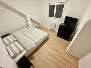 - une petite chambre avec un lit et une télévision dans l'établissement Maison plein cœur de Rosendael, à Dunkerque