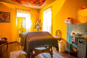 een slaapkamer met gele muren en een bed in een kamer bij The Goddess Garden Eco-Resort in Cahuita