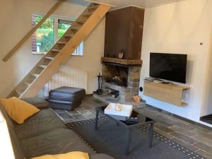 a living room with a couch and a television at La Maisonnette in Porcheresse