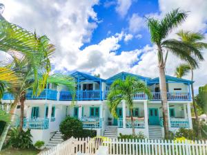 una casa azul con palmeras delante en B&B Aparthotel La Isleta, en Las Galeras