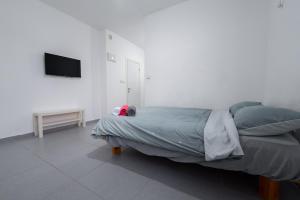 Schlafzimmer mit einem Bett und einem Flachbild-TV in der Unterkunft Luxury studio 5 min from beach in Rischon LeZion
