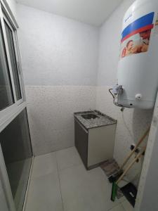 een kleine badkamer met een toilet en een watertank bij DEPARTAMENTO AMOBLADO PARQUE SAN VICENTE in Godoy Cruz