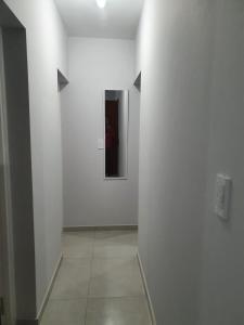 un pasillo con una pared blanca y un espejo en DEPARTAMENTO AMOBLADO PARQUE SAN VICENTE en Godoy Cruz