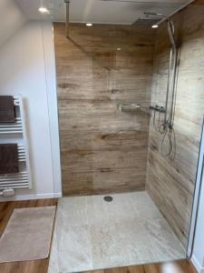 y baño con ducha y pared de madera. en *NEU* Extravagantes Eifelhaus am Nürburgring, en Mannebach