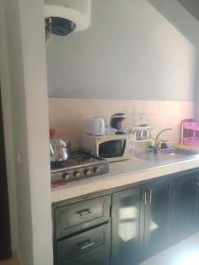 a kitchen with a stove and a microwave at Dar yassmine in Ifrane