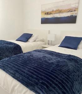 twee bedden naast elkaar in een slaapkamer bij 610 Suite con terraza Puerto de la Cruz Martianez in Puerto de la Cruz