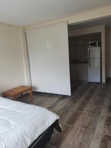 Habitación con cama y cocina con nevera. en Mono Villegas 1 en San Carlos de Bariloche