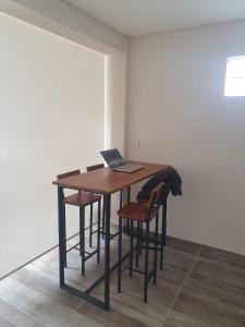 una mesa con sillas y un ordenador portátil encima. en Mono Villegas 1 en San Carlos de Bariloche