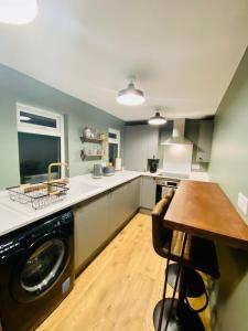 a kitchen with a washing machine and a wooden table at The Etherley - Zillo in Bishop Auckland