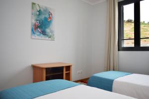 豐沙爾的住宿－Sao Martinho, a Home in Madeira，客房设有两张床、一张桌子和一扇窗户。