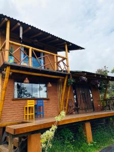 a wooden house with a balcony on top of it at Casa Lobo-guará in Alto Paraíso de Goiás