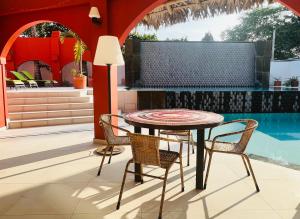 - une table et des chaises sur une terrasse avec piscine dans l'établissement New Nautilus Lodge, à Puerto López