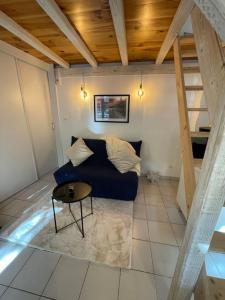 a living room with a blue couch and a table at Studio la maison dorée à luchon in Luchon
