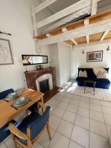 a living room with a table and a bed at Studio la maison dorée à luchon in Luchon