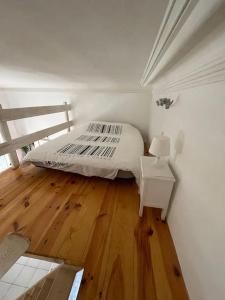 a bedroom with a bed and a wooden floor at Studio la maison dorée à luchon in Luchon +8 photos
