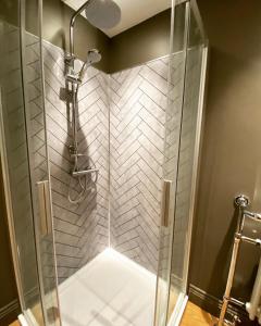 a shower with a glass door in a bathroom at The Etherley - Zillo in Bishop Auckland