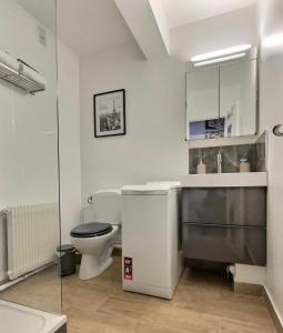 a white bathroom with a toilet and a sink at Studio confort Vanves Paris Porte de Versailles in Vanves