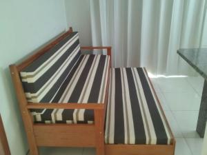 - un banc en bois avec des coussins rayés dans la chambre dans l'établissement Pousada Vila dos Pescadores, à Pinheira