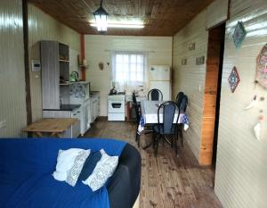 Habitación pequeña con cama y cocina en Cabaña La Genio, en Punta del Diablo