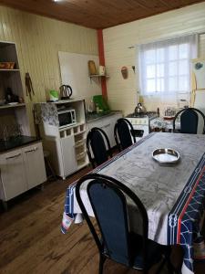 a kitchen with a table and chairs in a room at Cabaña La Genio in Punta Del Diablo