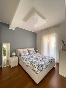 1 dormitorio con 1 cama con edredón azul y blanco en Il Salotto sul Mare, en Messina