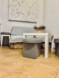 a table and two stools in a room with a bench at Favorit Apartoment in Lviv