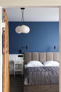 a blue bedroom with a bed and a blue wall at Sea Zone Apartament przy parku in Wejherowo