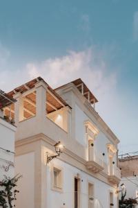 - un bâtiment blanc avec un balcon au-dessus dans l'établissement LE MAIOLICHE - Apulian B&B, à Grottaglie