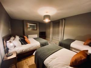 una camera d'albergo con due letti e una camera con due di The Etherley - Zillo a Bishop Auckland