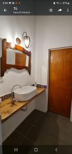 y baño con lavabo y espejo. en Casa cerca del lago San Roque en Córdoba