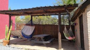 dos hamacas y una mesa de picnic bajo una pérgola en Casa cerca del lago San Roque en Córdoba