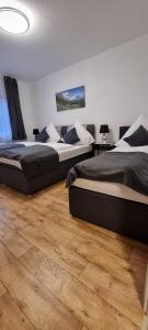 two beds in a room with wooden floors at Waterfalls Apartment 2 in Triberg