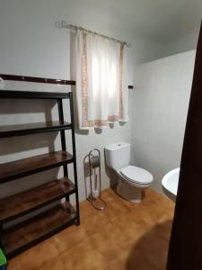 y baño con aseo blanco y lavamanos. en Casa El Tío Juan, en Cumbres de San Bartolomé