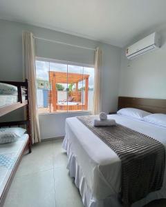 1 dormitorio con 2 camas y ventana grande en Recanto da Natureza & SPA, en Penha