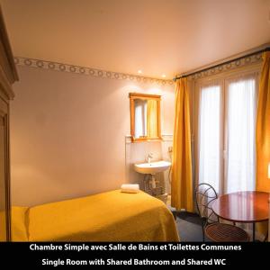 sypialnia z łóżkiem, stołem i lustrem w obiekcie Port Royal Hotel w Paryżu
