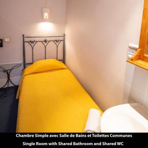 a bedroom with a yellow bed with a yellow blanket at Port Royal Hotel in Paris