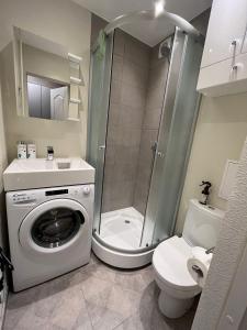 a bathroom with a shower and a washing machine at Beautiful Apartment Great Location FREE PARKING in Rīga