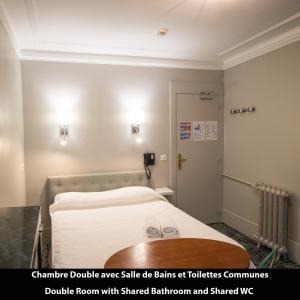 une chambre à l'hôpital avec un lit avec des draps blancs dans l'établissement Port Royal Hotel, à Paris