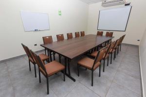 une salle de conférence avec une table et des chaises en bois dans l'établissement Casa Andina Standard Talara, à Talara