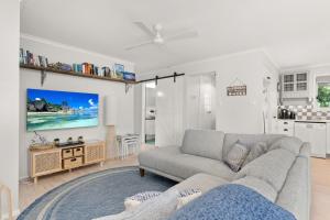 ein Wohnzimmer mit einem Sofa und einem TV in der Unterkunft Bayview Cottage in Ventnor