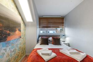 1 dormitorio con 1 cama con toallas en Cadwell Serviced 4 Bedroom House with Parking Maidenhead by 360Stays en Maidenhead
