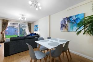 - un salon avec une table et des chaises dans l'établissement Cadwell Serviced 4 Bedroom House with Parking Maidenhead by 360Stays, à Maidenhead