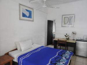 1 dormitorio con cama, escritorio y mesa en Olivias Accommodation en Apia