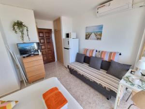 a living room with a couch and a tv at Estudio Las Naciones Bellavista in Benalmádena