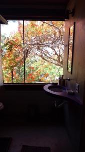 a bathroom with a large window and a sink at Pousada Recanto Devas in Cabo Frio