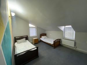 two beds in a room with two windows at Sargsyans guest hause in Bjni