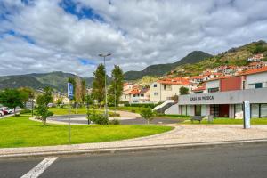una calle en una ciudad con montañas en el fondo en Nidia’s Place, a Home in Madeira, en Machico