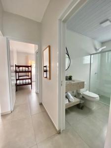a white bathroom with a toilet and a sink at Recanto da Natureza & SPA in Penha