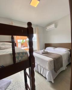 1 dormitorio con 2 camas y ventana en Recanto da Natureza & SPA, en Penha